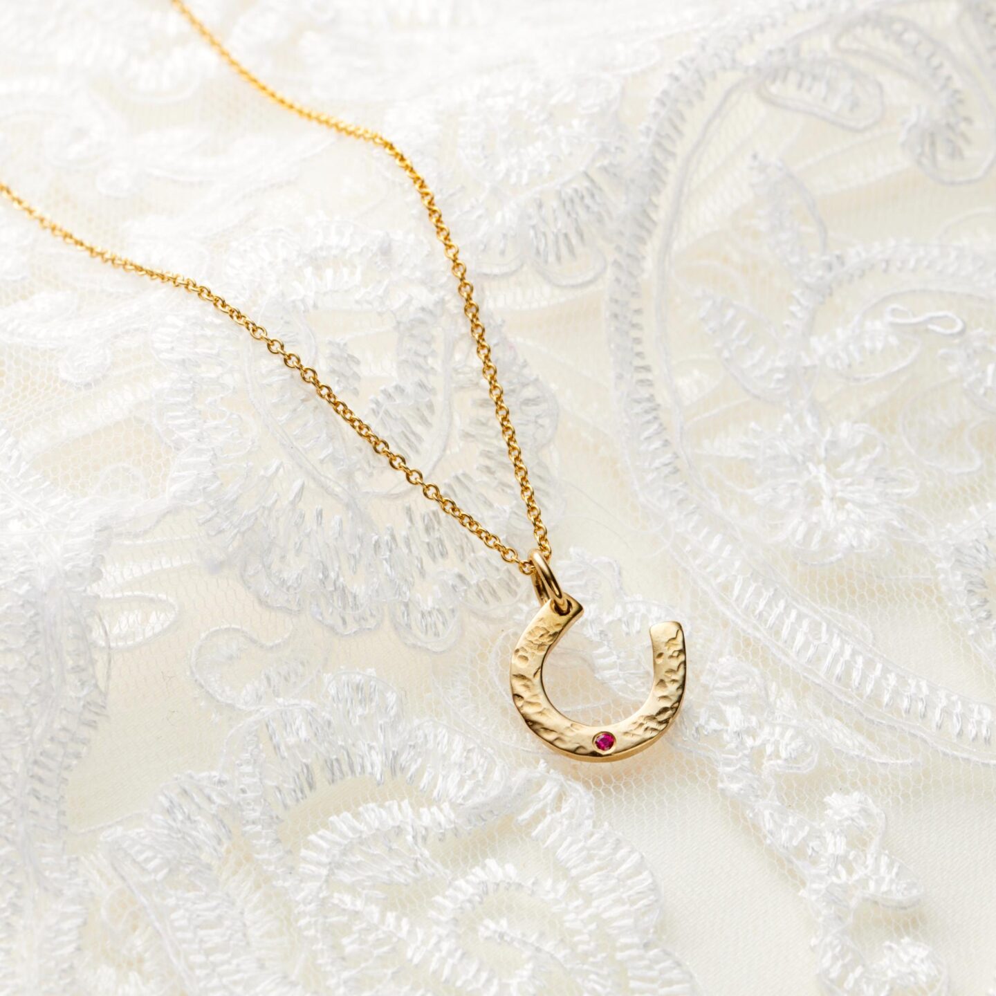 Gold and garnet horseshoe birthstone necklace